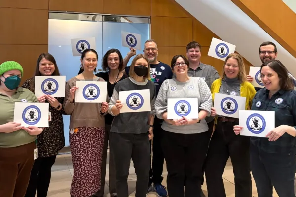 American Library Association employees hold up signs with their new union logo on them.